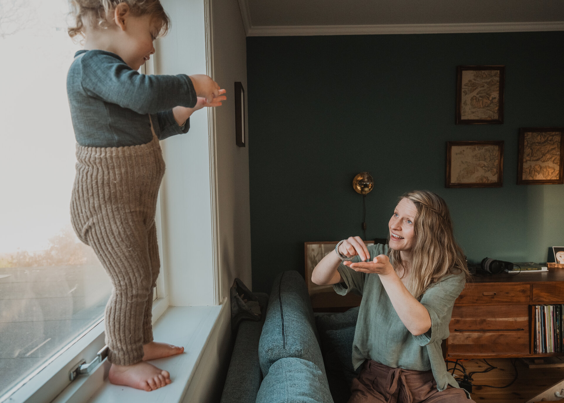 A baby looking intently at their parent's hands.